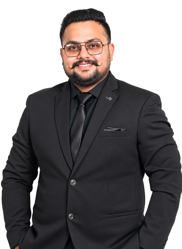 Harminder S in a black suit, smiling